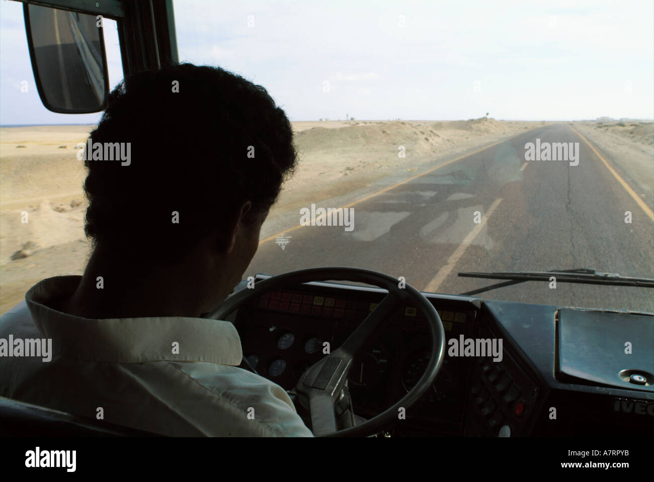 Egypt between quoseir and marsa alam man driving a bus on a highway Stock Photo