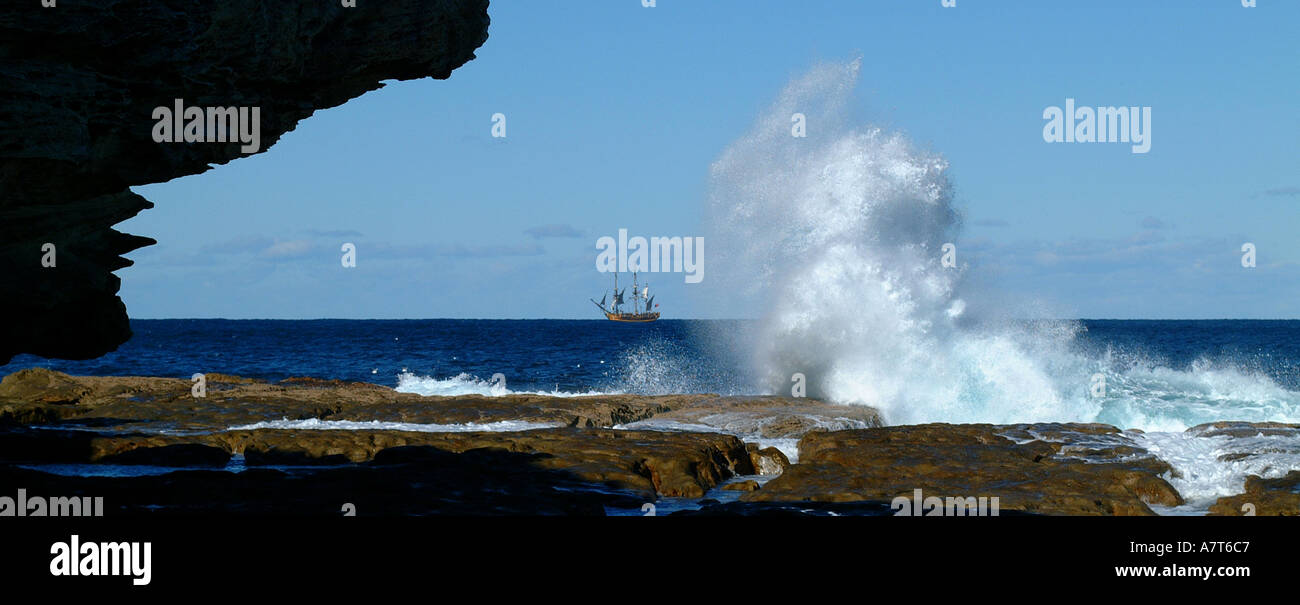 Bondi Beach waves clashing against rocks with tale ship in the distance in Sydney Austraila Stock Photo