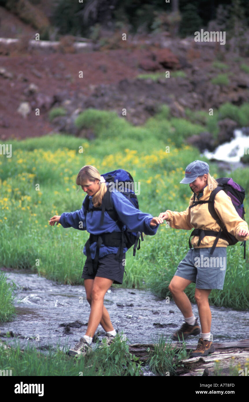 Two Women Crossing a Stream Together Stock Photo Alamy