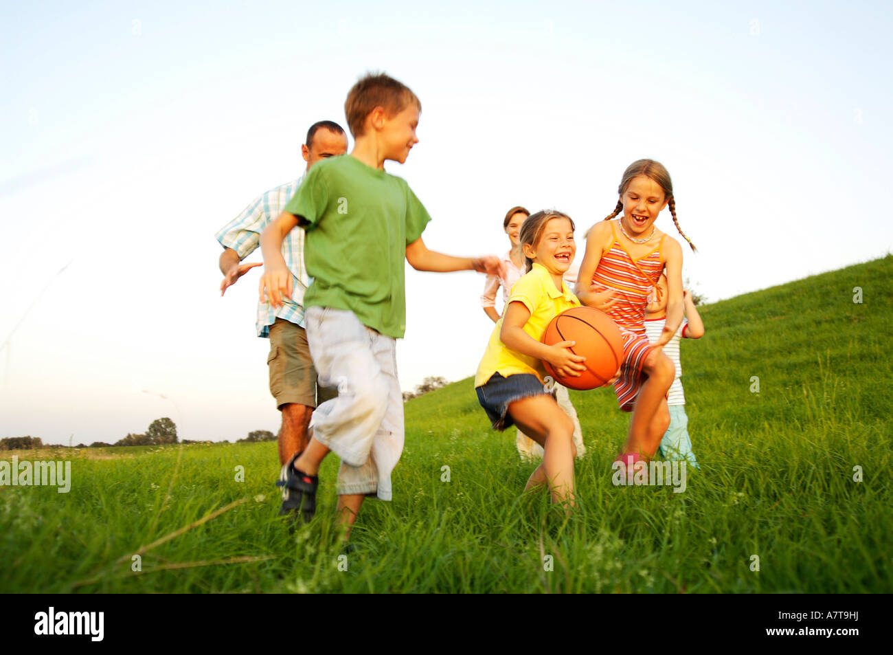 Family playing basketball in field Stock Photo - Alamy