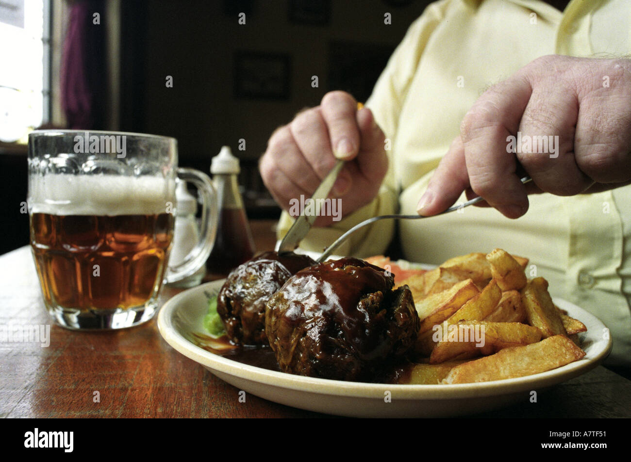 A traditional Black Country meal of faggots and chips served at the Wheatsheaf pub in West Bromwich UK Stock Photo