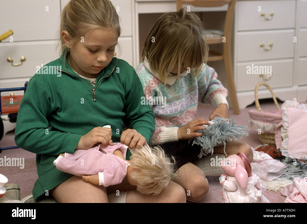 young girls playing with dolls Stock Photo