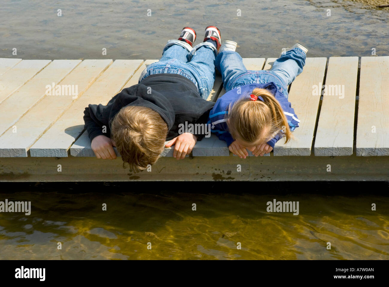 A Brother and Sister looking into Water from Staith RutlandWater Stock Photo