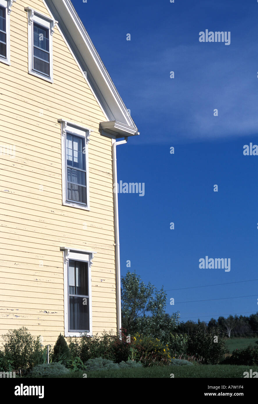 Side of yellow clapboard house against dark blue sky in New Mills New Brunswick Canada Stock Photo