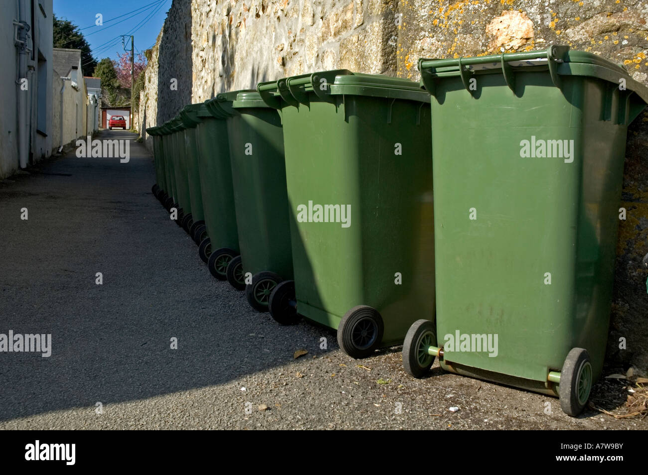 a row of green wheelie bins ready for rubbish collection in cornwall
