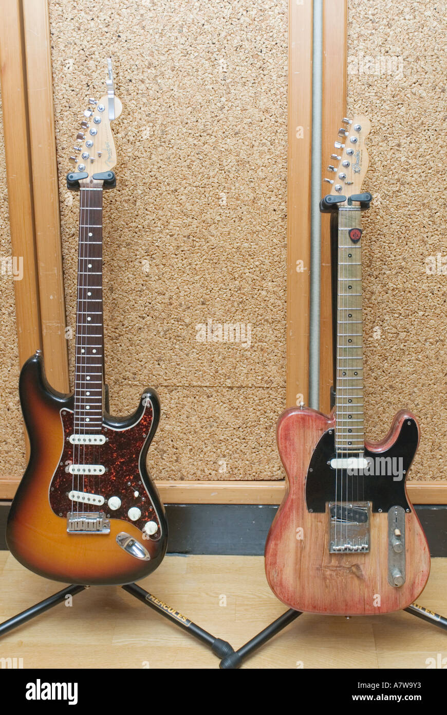 Electric guitars on stands against wall in music recording studio Stock