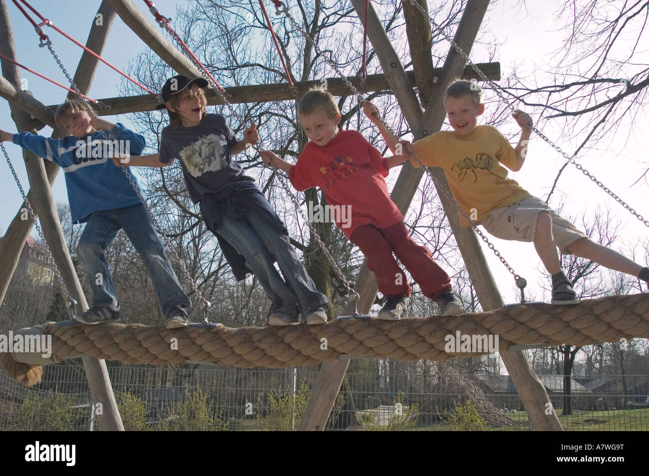 Four children on a large swing Stock Photo