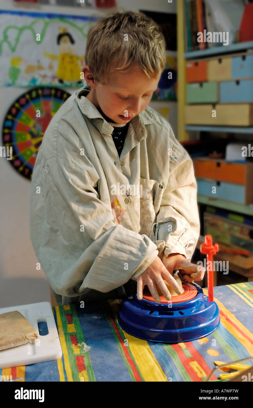 Young boy making pottery with a potter's wheel Stock Photo
