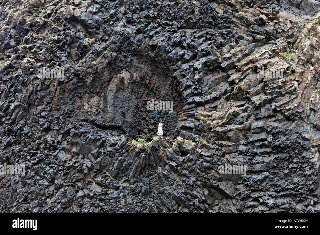 Basalt rock with a statue of the holy Maria, Ribeira da Janela, Madeira, Portugal Stock Photo