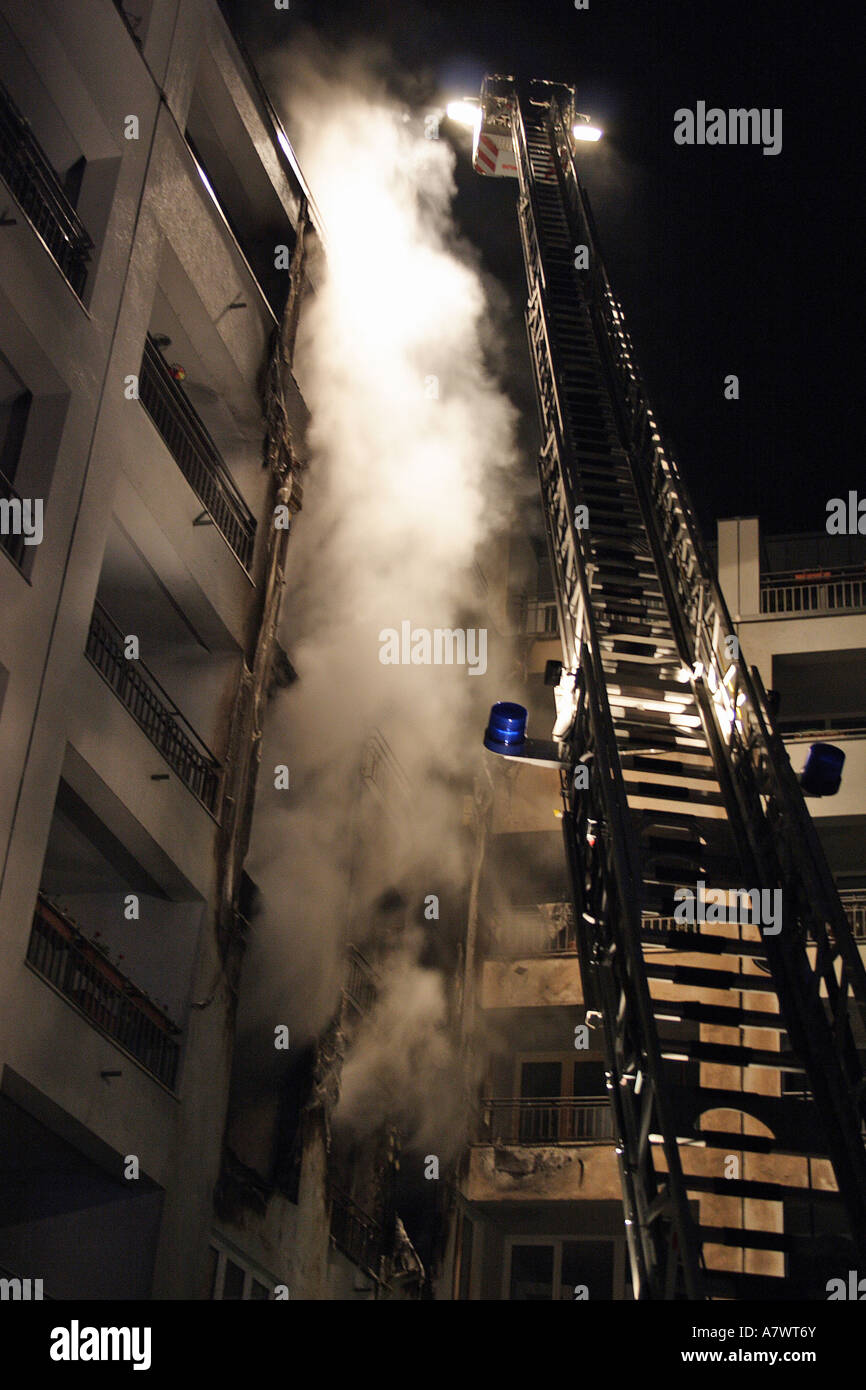 Fire Brigade extinguishing a burning appartment house Stock Photo