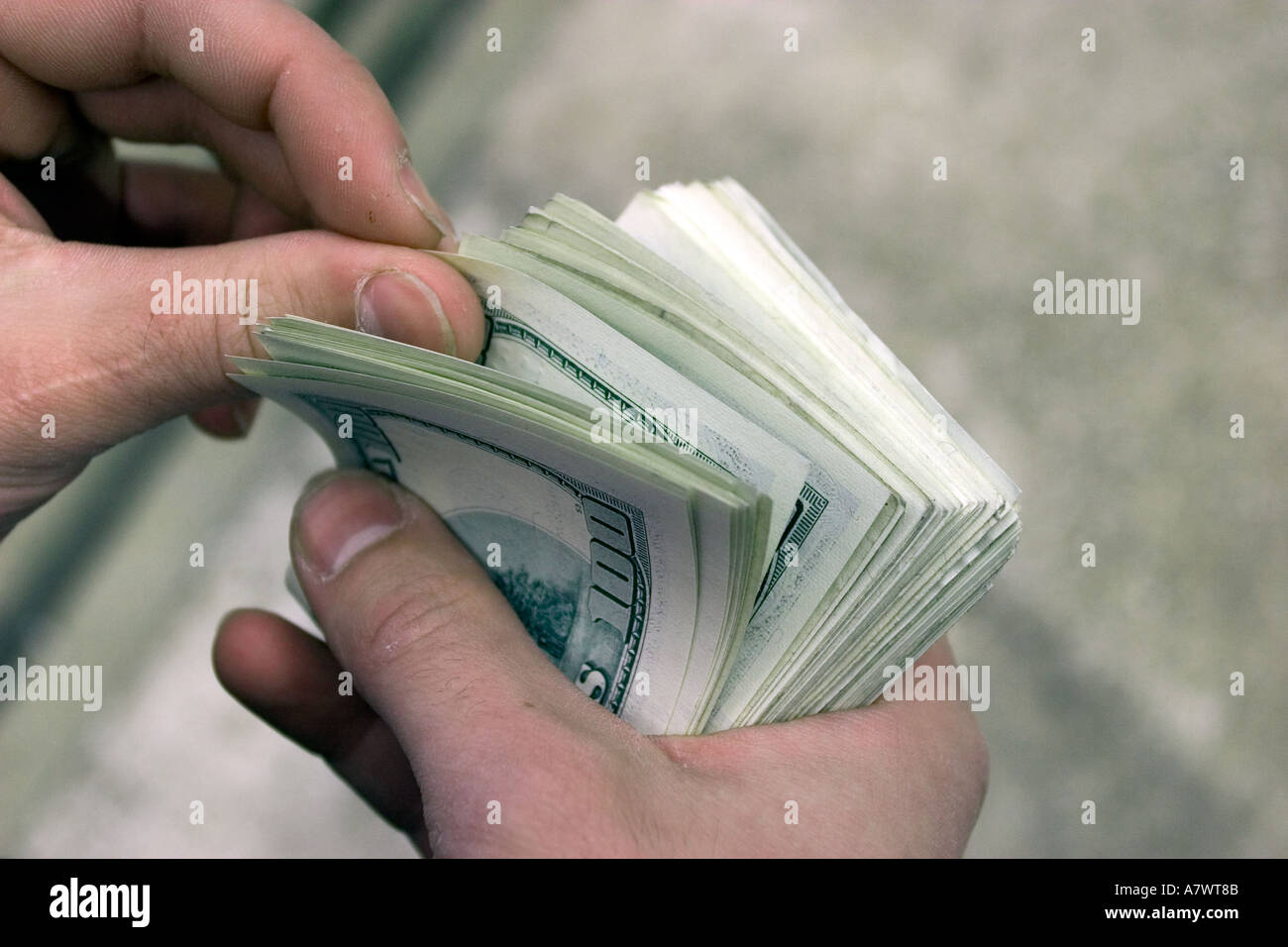 details of hand and fingers of man counting bundle of one hundred american dollars currency Stock Photo