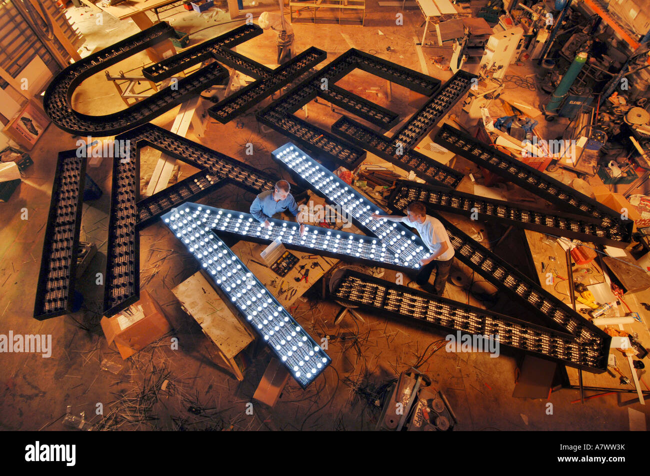 A pile of giant letters being fitted with lights by electricians Stock Photo