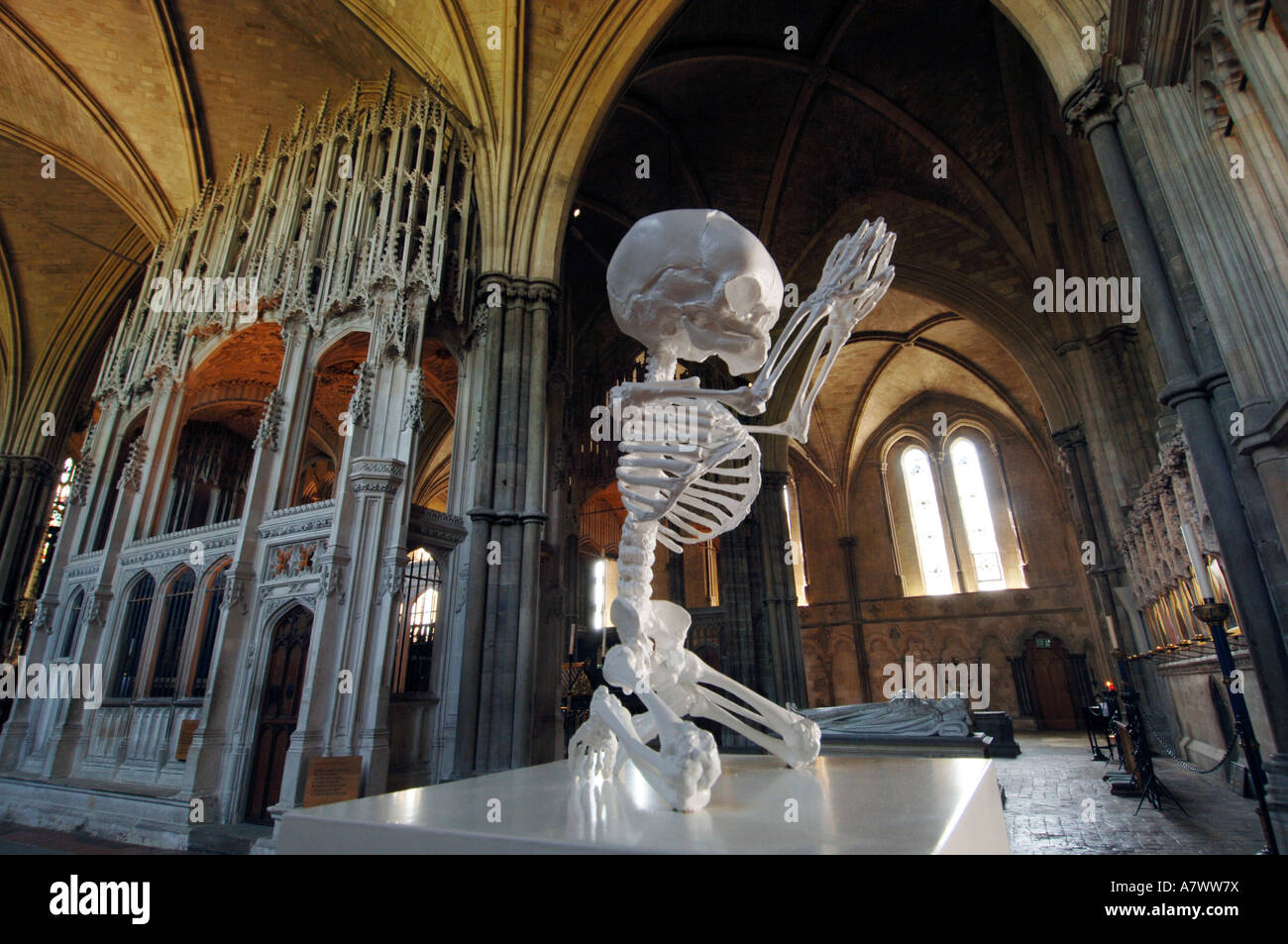 A sculpture of a foetal skeleton kneeling in prayer by Mark Quinn at Winchester Cathedral Stock Photo