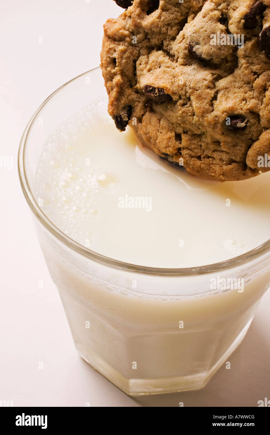 Chocolate chip cookie being dipped in milk, vanilla, chocolate chip