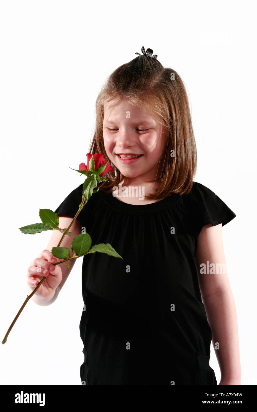 Young girl smelling a red rose in a white studio setting Stock Photo ...