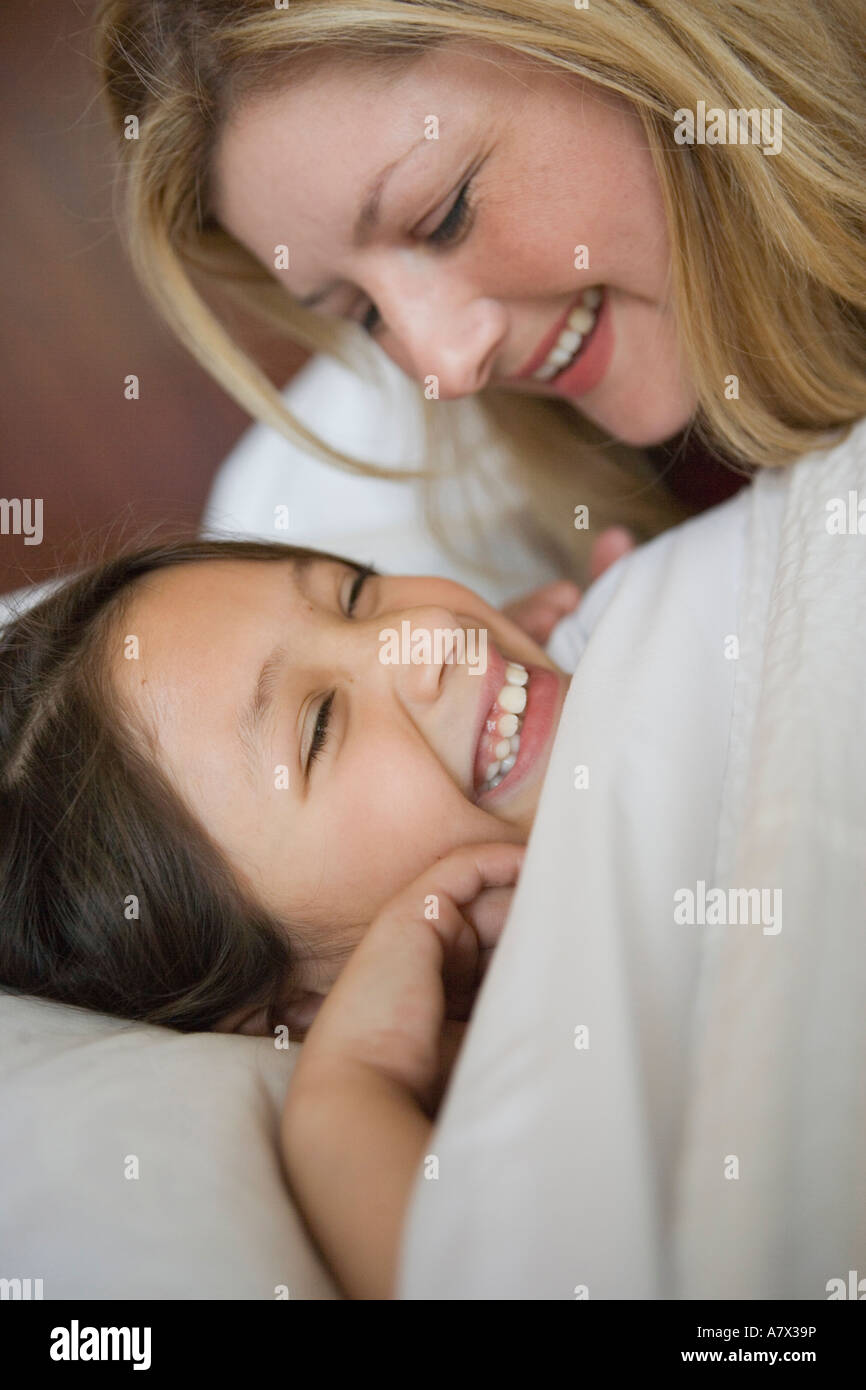 mother putting child to bed, joking with daughter, closeup Stock Photo