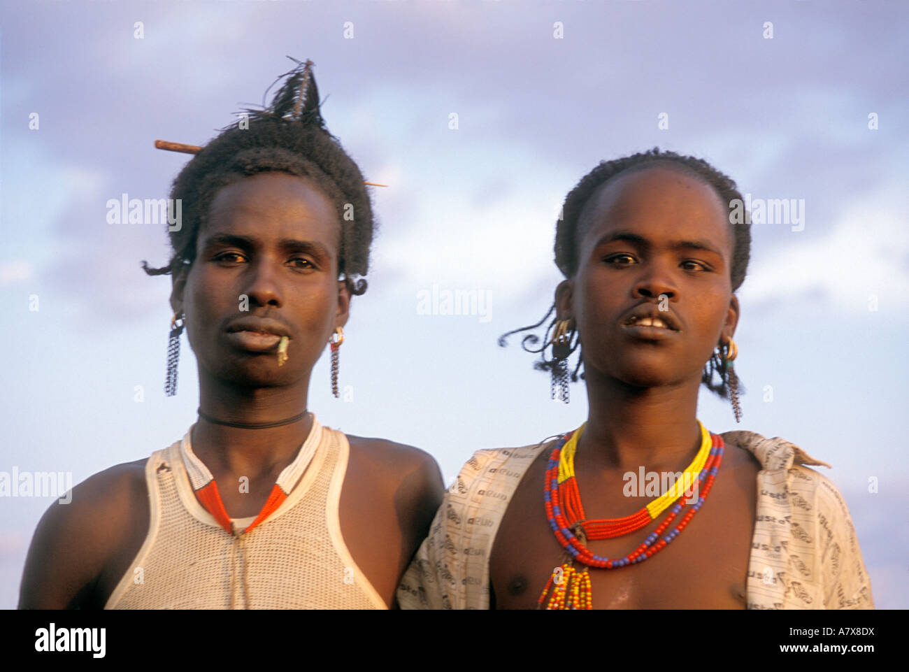 Two Hamar boys with traditional hairstyles and jewelry, despite their Western-style clothes, in Ethiopia's Omo River region Stock Photo