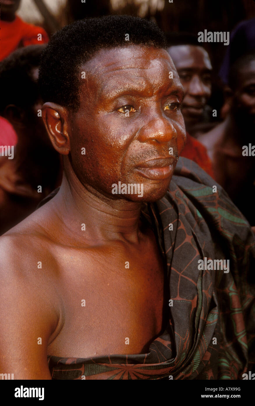 Ghana: Nsawkaw (Brong-Ahafo Region), village elder attending funeral wearing Adinkra cloth togo-style, March. Stock Photo