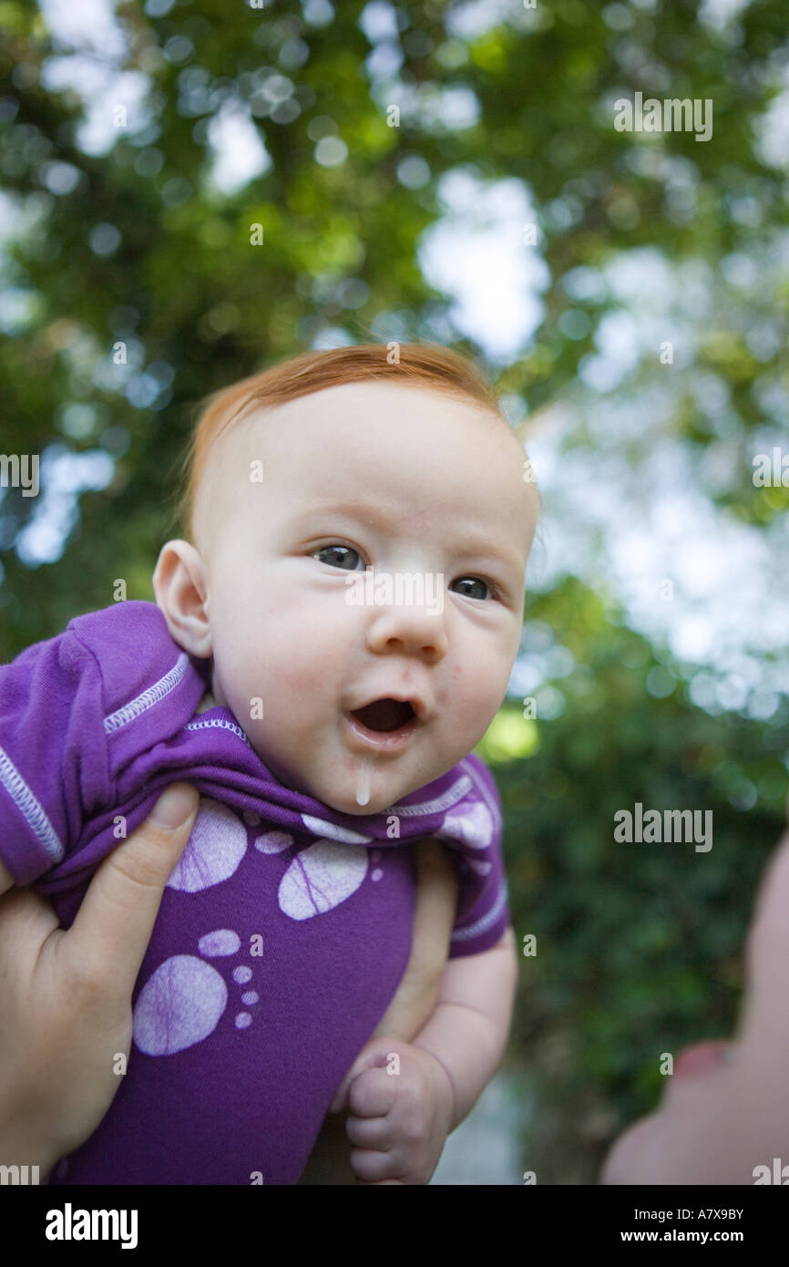 surprised infant making eye contact with camera while being held by