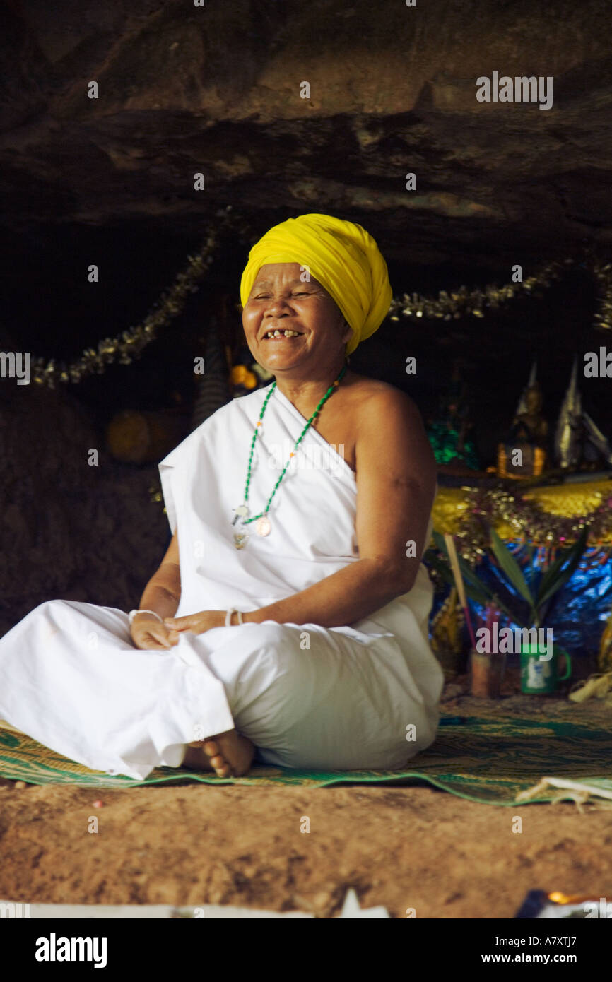 Female Buddhist leader and animist ascetic laughing in her cave above Ban Mai Singsamphan, Laos Stock Photo