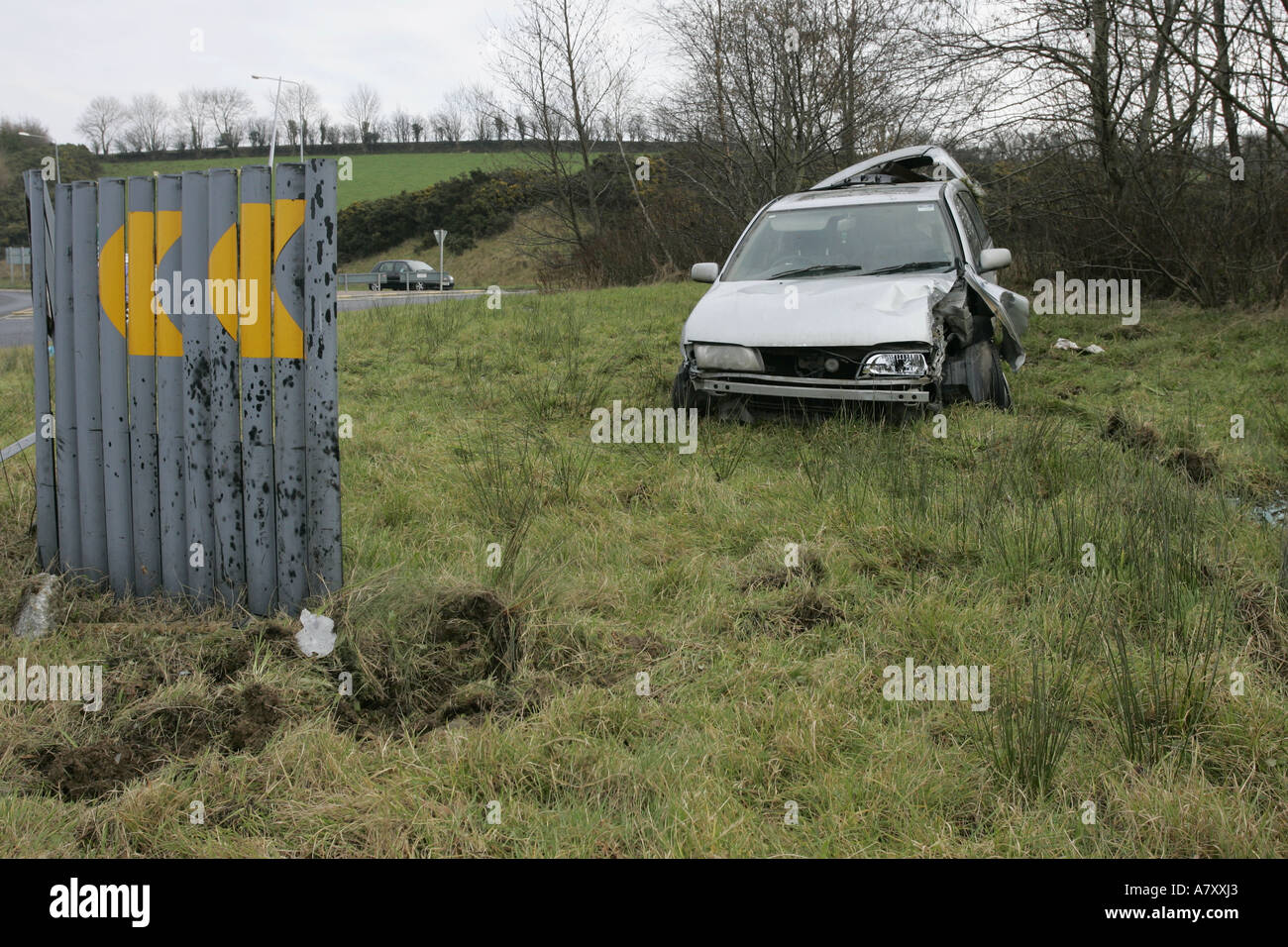 road traffic accident with crashed car and warning sign on a roundabout outside Letterkenny County Donegal Republic of Ireland Stock Photo