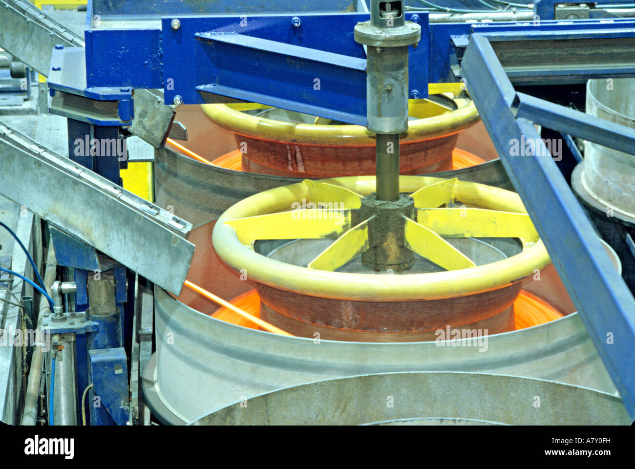 Foundry coiling hot brass rod Stock Photo - Alamy
