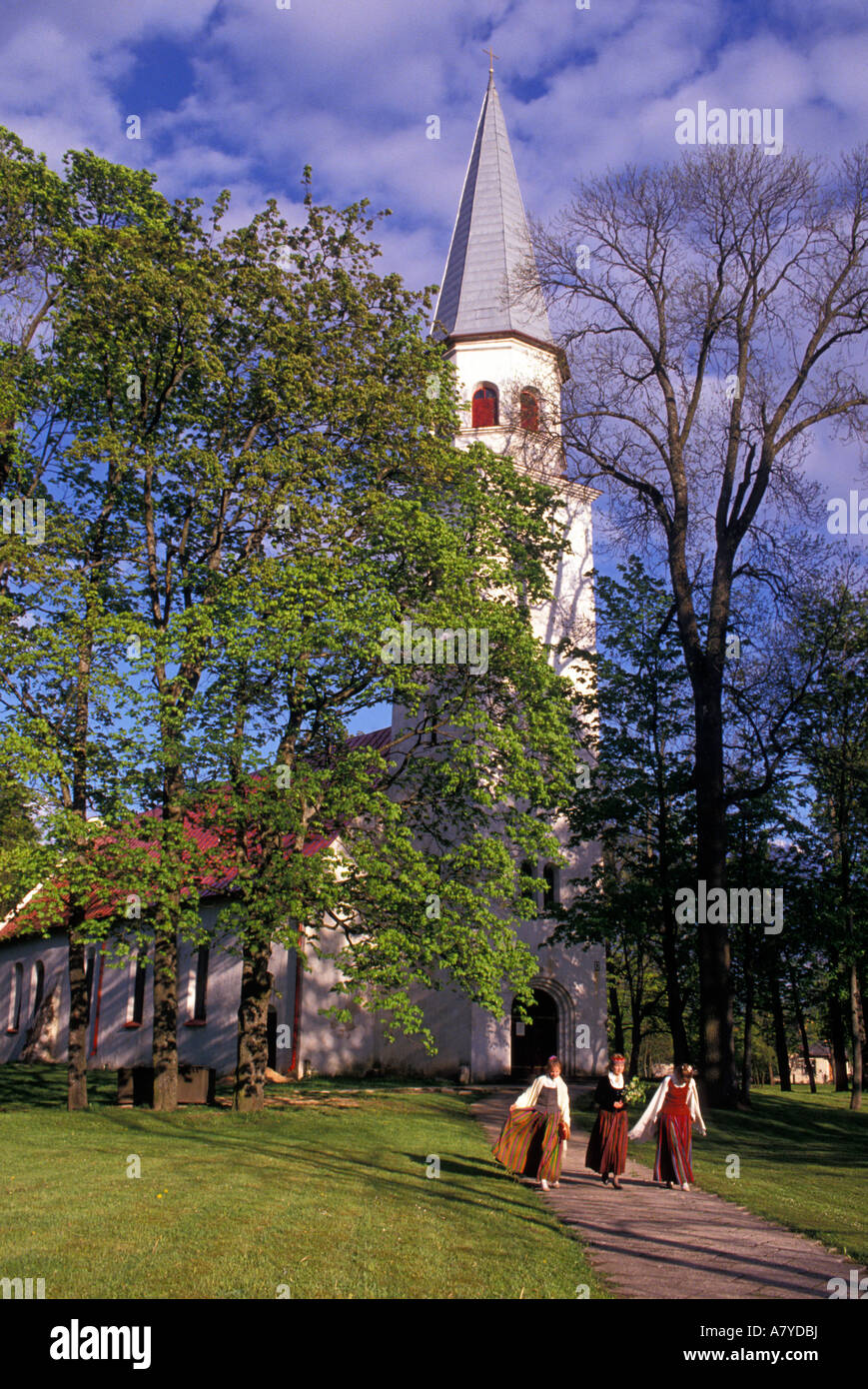 Three girls in traditional Latvian clothes coming from a church in Sigulda within the Gauja National Park, Latvia. Stock Photo