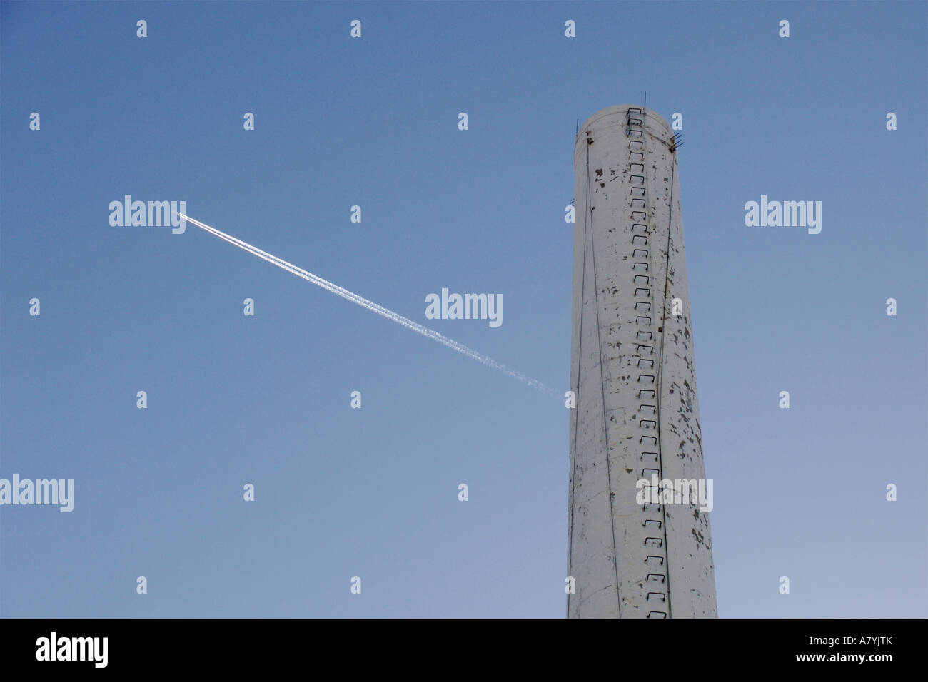 Jet contrail and smokestack Chicago Illinois Two sources of greenhouse gases Stock Photo