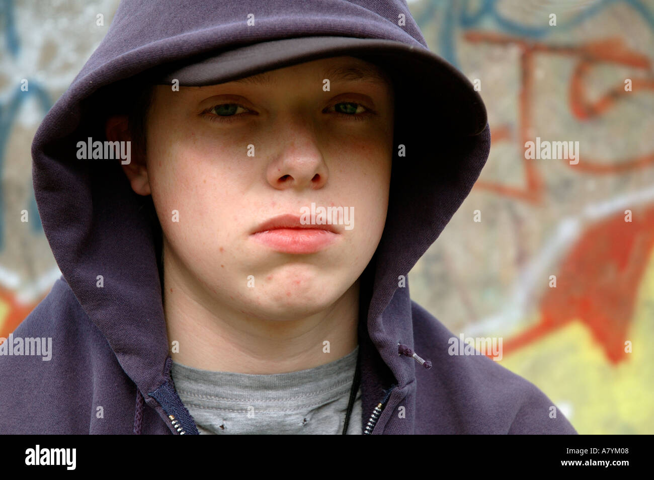 Young boy hanging around the streets dressed in hoodie looking threatening and bored. Stock Photo