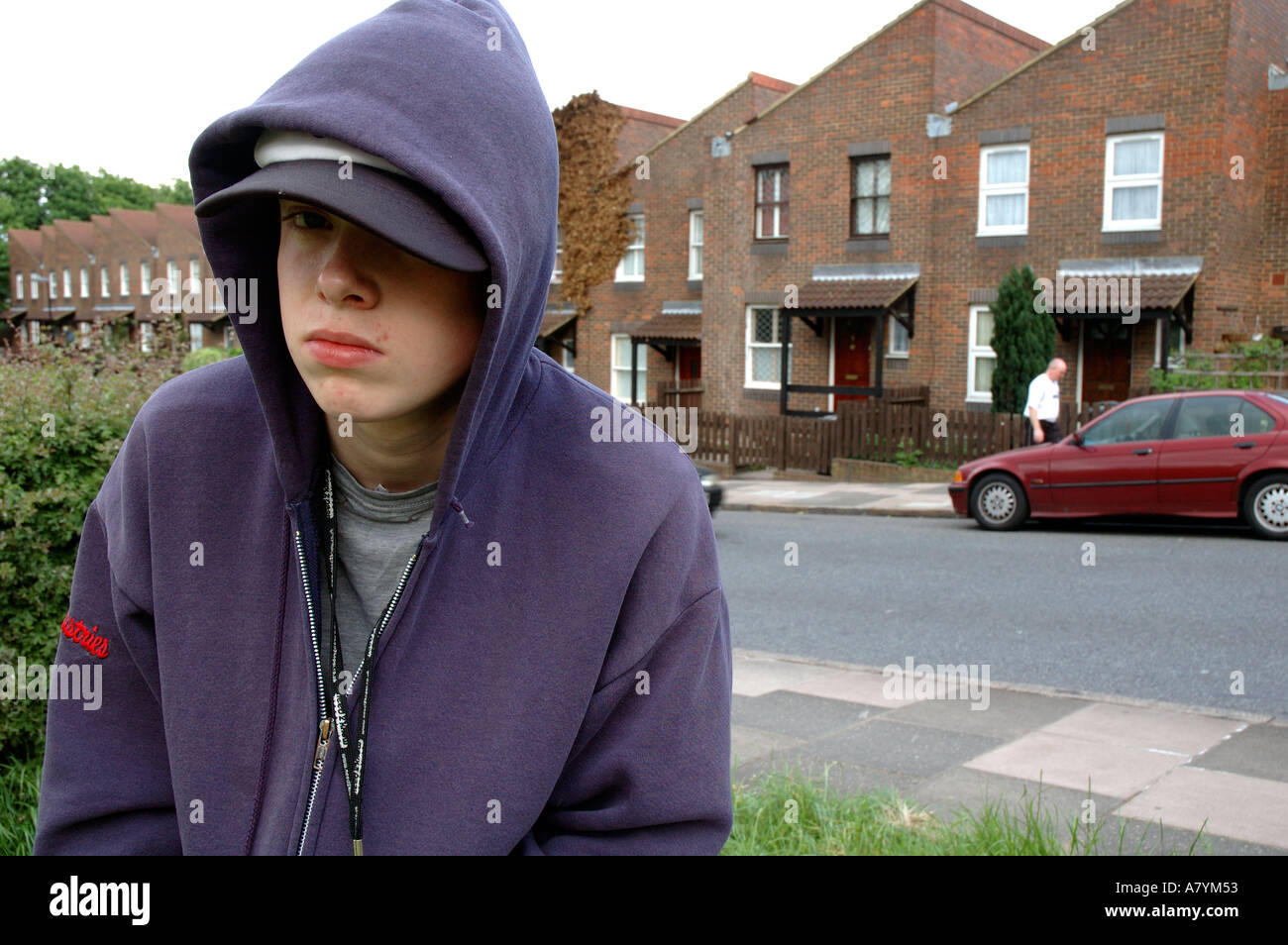 Young boy hanging around the streets dressed in hoodie looking threatening and bored. Stock Photo
