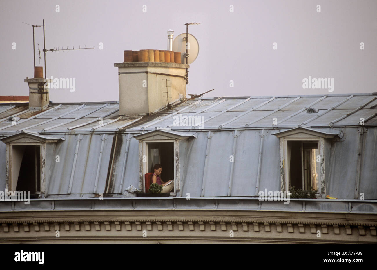 Student sits in her garret window in Montmartre Stock Photo