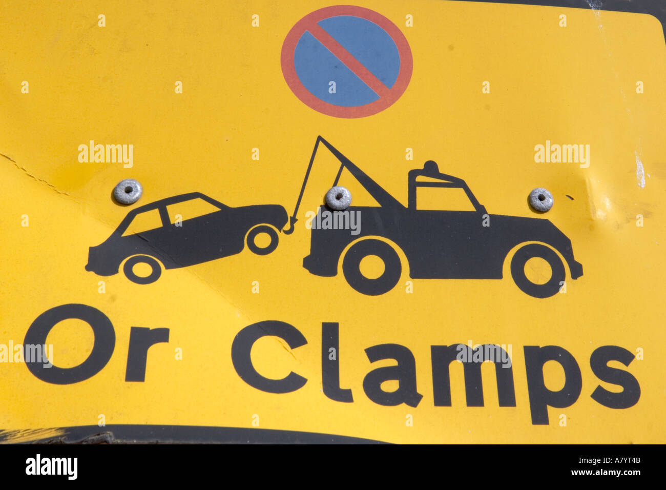 Pictograph sign of tow truck taking car in no parking zone and warning words Or Clamps Stock Photo