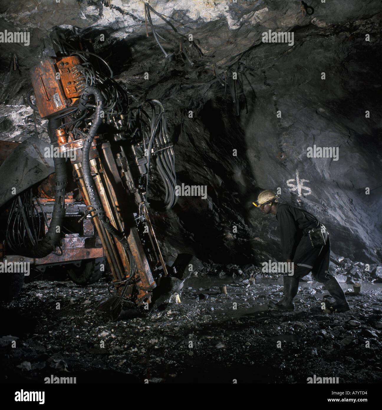 Miner drilling for core samples at underground gold mine in Obuasi