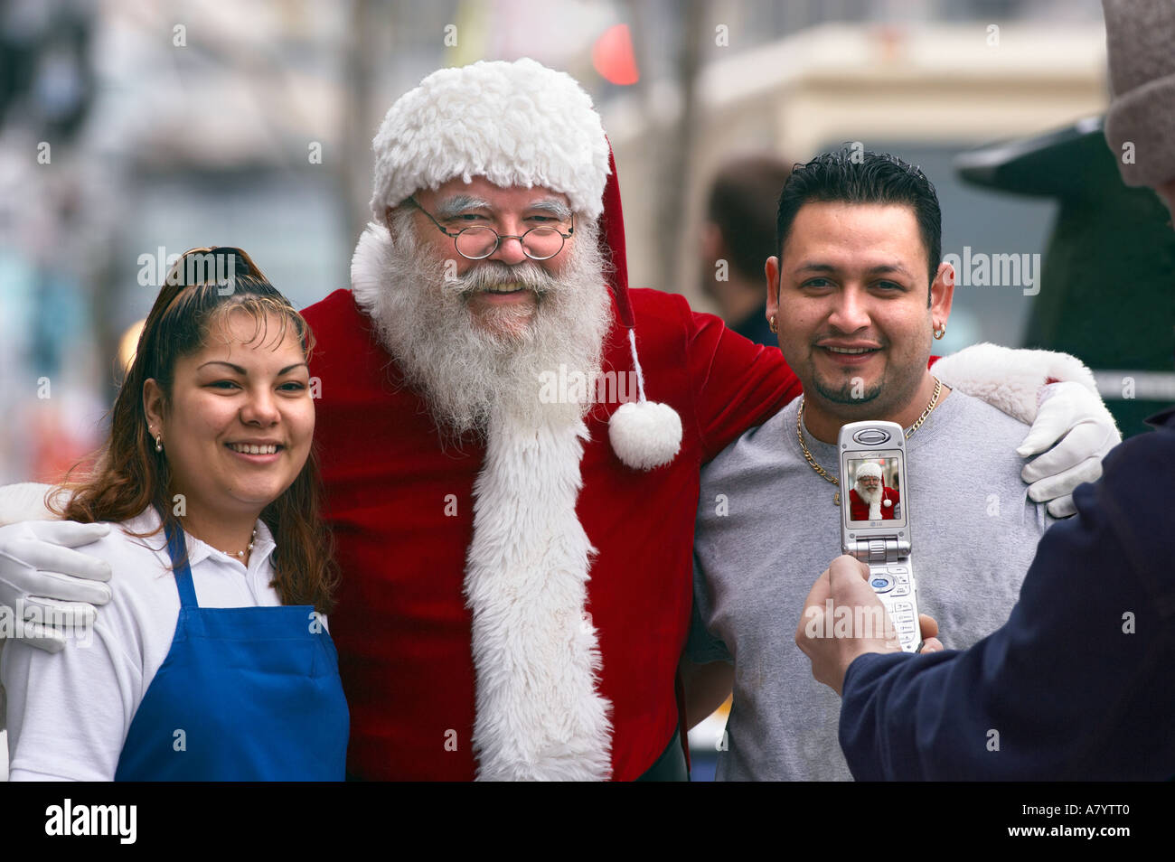 Santa claus poses with latino couple Stock Photo - Alamy