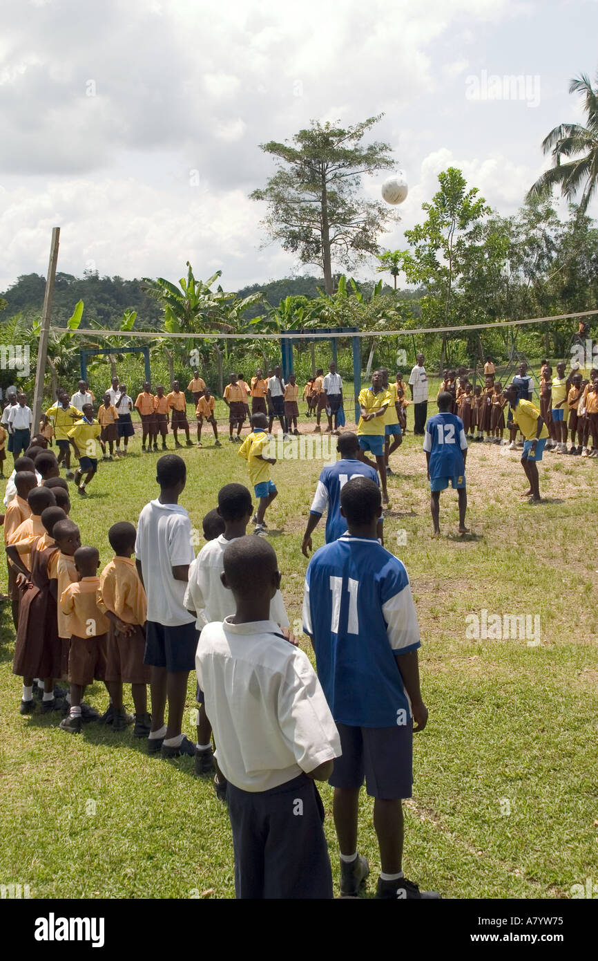 Teenage boy students playing in a school volleyball match on sports ground with supporters watching from side lines, Western Region, Ghana West Africa Stock Photo