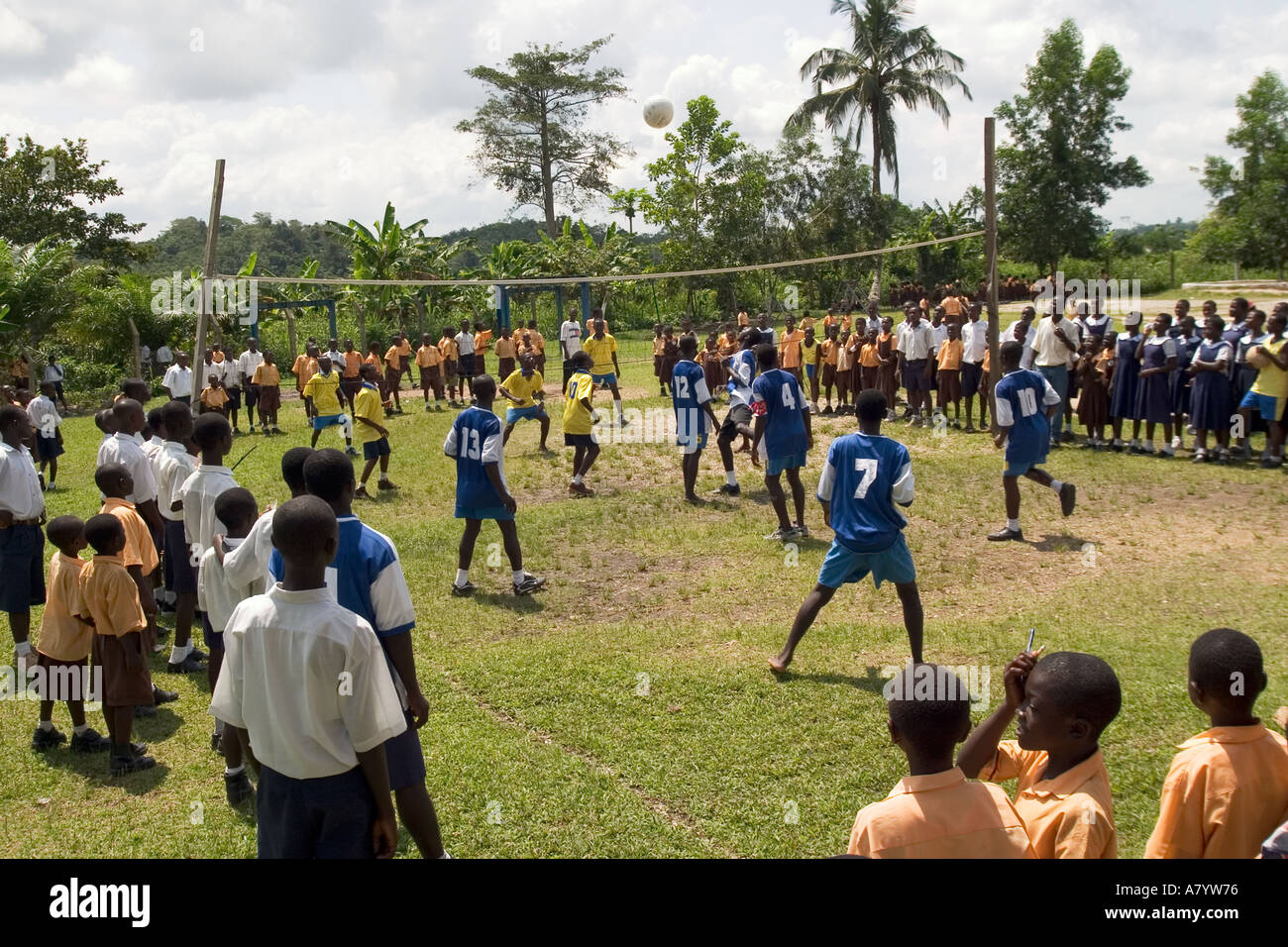 Teenage boy students playing in a school volleyball match on sports ground with supporters watching from side lines, Western Region, Ghana West Africa Stock Photo