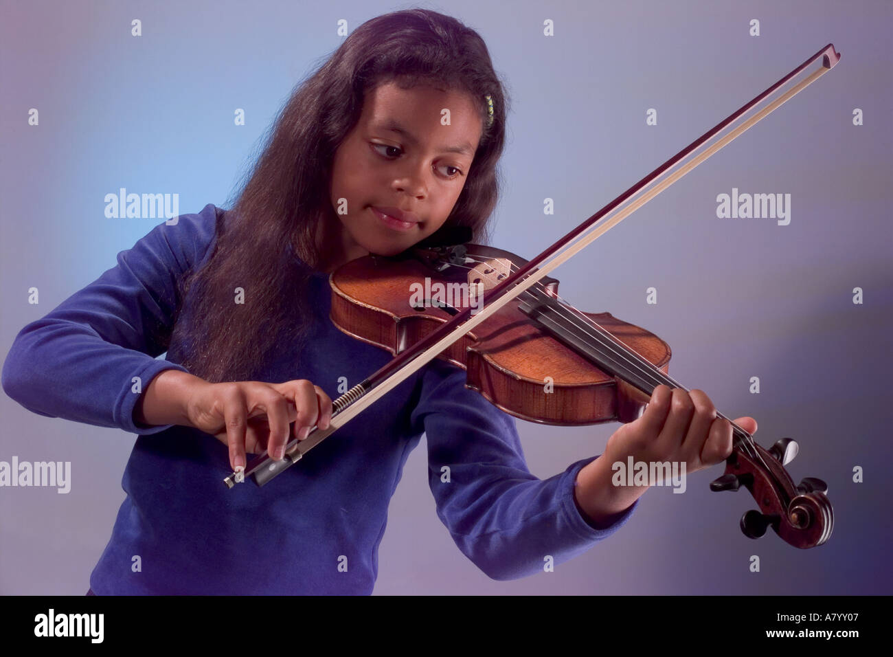 Young girl student violinist of ethnic origin practising playing the violin Stock Photo