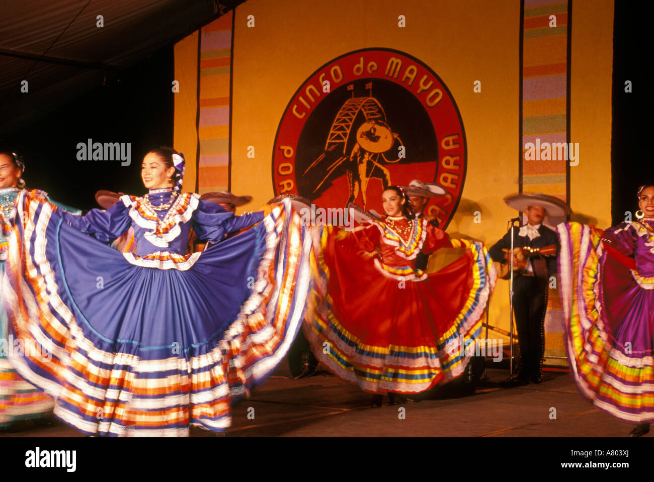 Dancers in traditional Mexican dress twirl their brightly-colored skirts at the Cinco de Mayo festival in Portland, Oregon. Stock Photo
