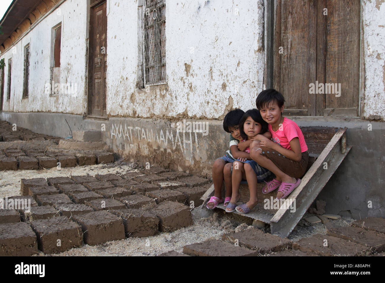Girls Sitting Next To Drying Mud Bricks, Tashkent Stock Photo