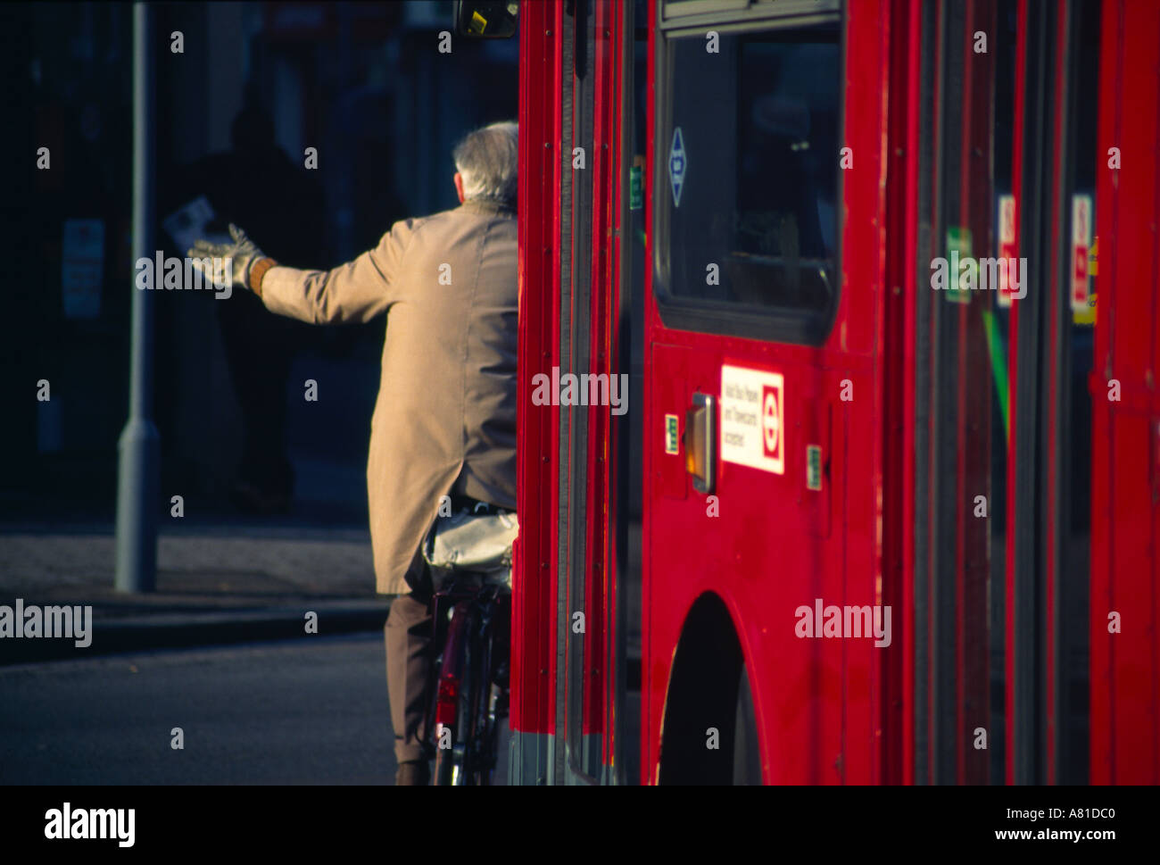 Cyclist in bus lane with red London bus close behind Stock Photo - Alamy