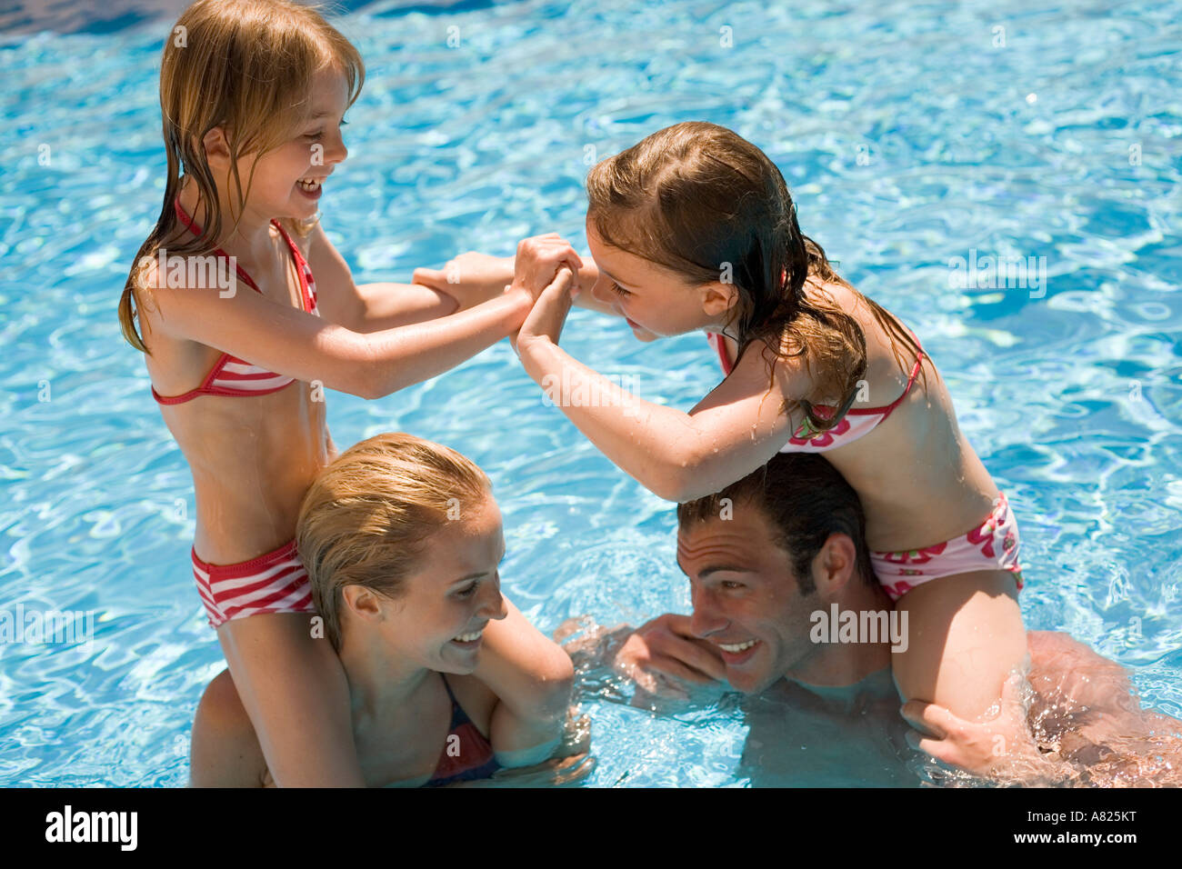Parents with children on their shoulders in a pool Stock Photo Alamy