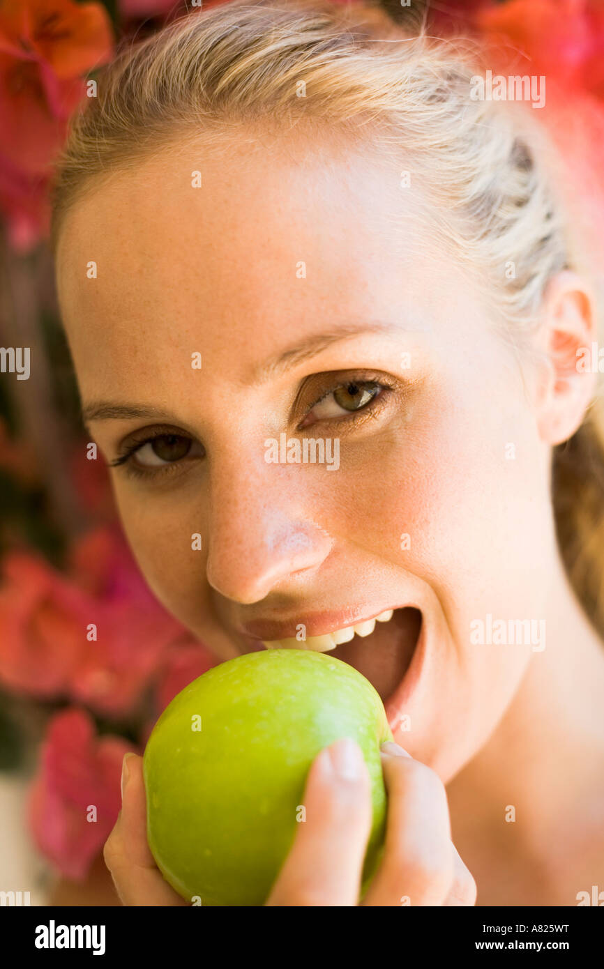 A woman eating a green apple Stock Photo Alamy
