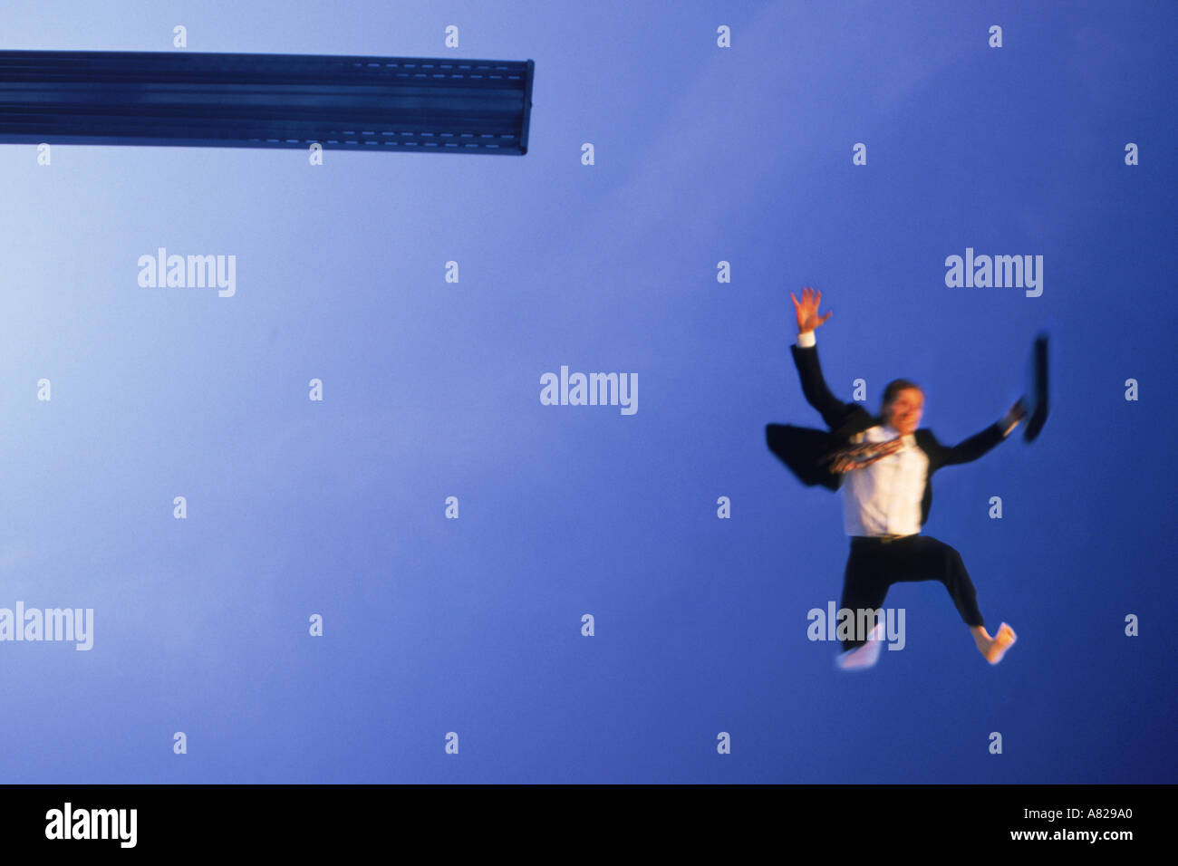 Crazy businessman jumping off diving board in desperation and frustration Stock Photo