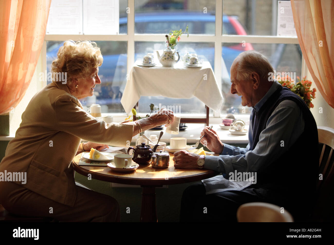 The town of Stow on the Wold in Gloucestershire UK An elderly couple enjoy afternoon tea in "Freebus" in Digbeth Street Stock Photo