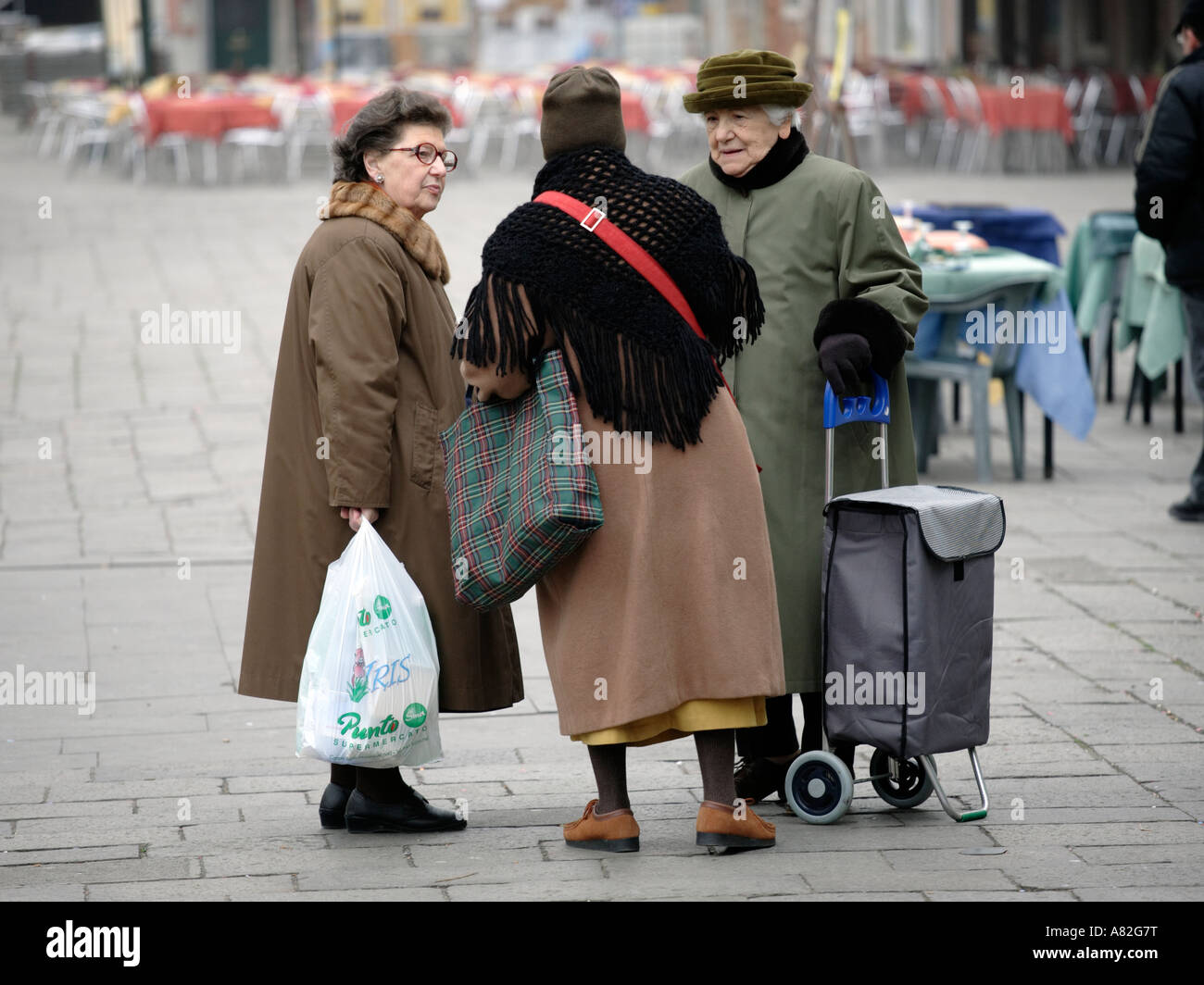 Three older women talking in a square in Venice Italy Stock Photo