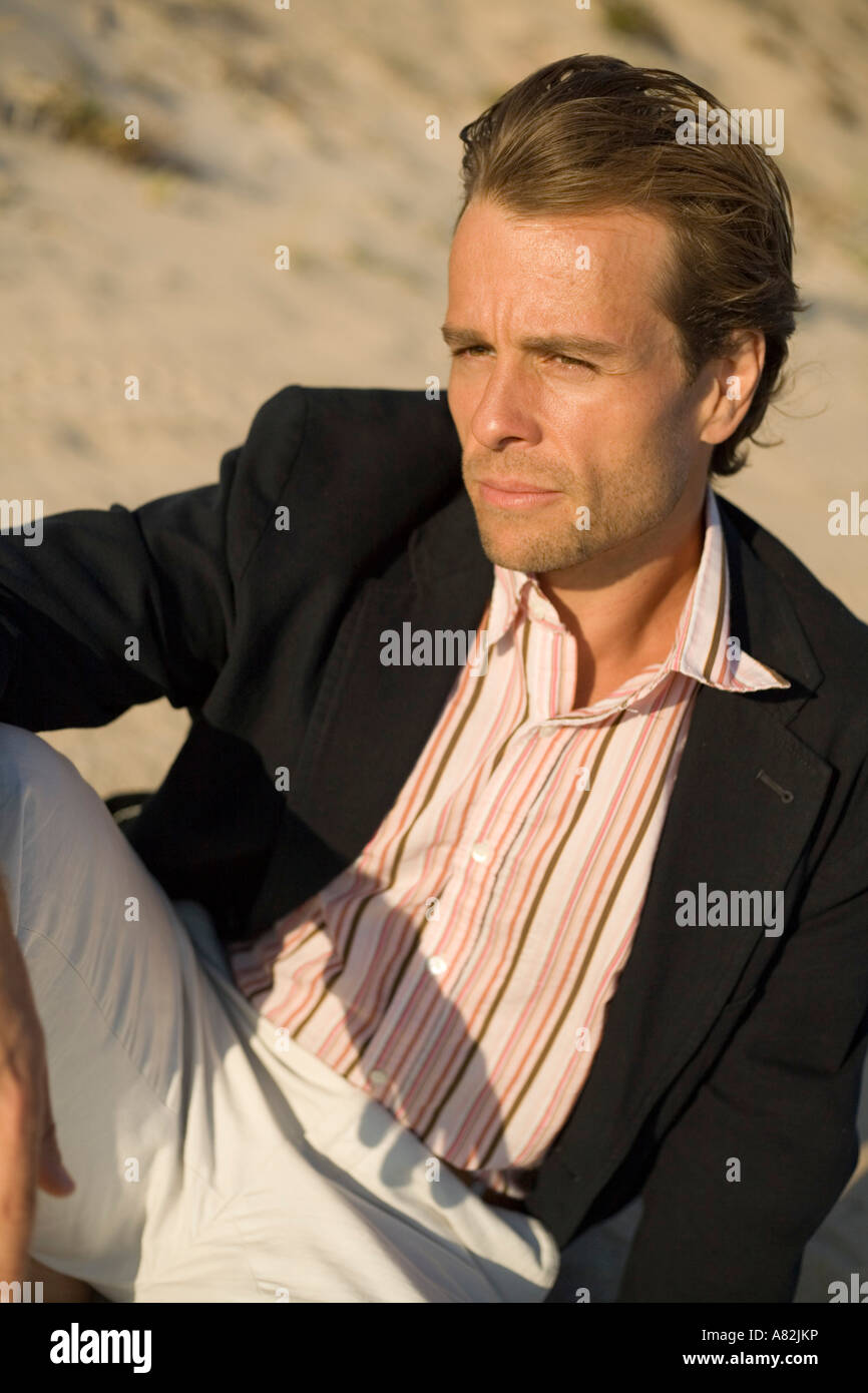 A man at the beach sitting in the sand Stock Photo Alamy