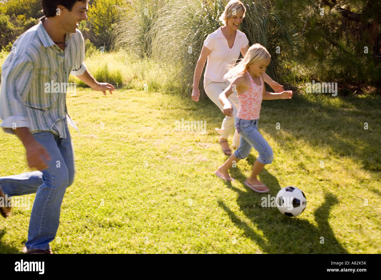 A family in a park playing with a soccer ball Stock Photo - Alamy