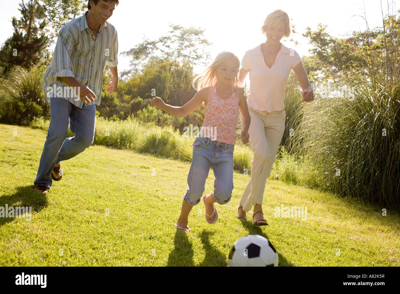 A family in a park playing with a soccer ball Stock Photo - Alamy