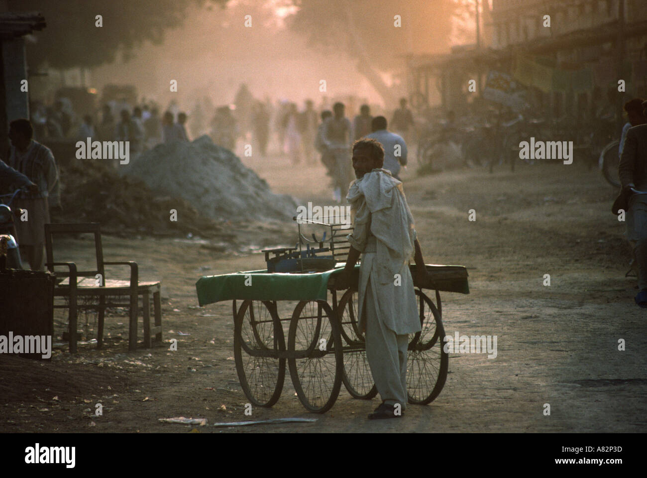 Pakistan South Punjab Bahawalpur market stallholder pushing empty stall home at end of day Stock Photo