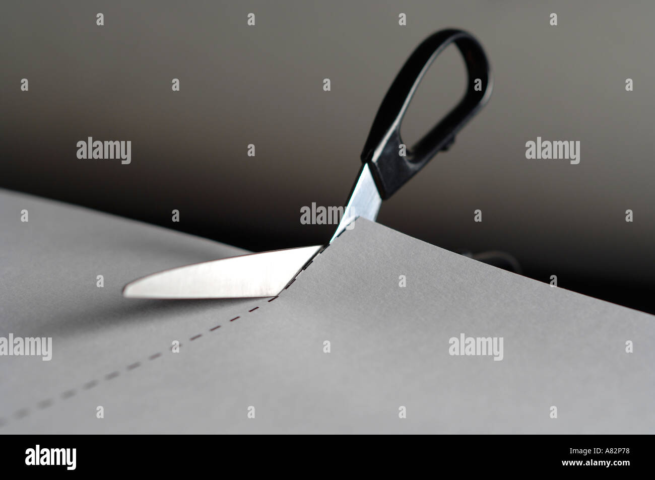 Scissors cutting paper along dotted line Stock Photo Alamy